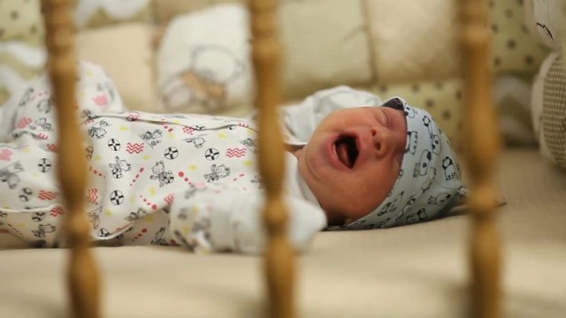 Newborn baby crying on the bed
