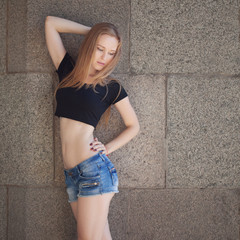 a young girl in shorts and a black topic in the city. bright emotions, style life