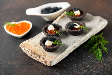 Black tartlets with red and black caviar