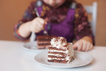 the child is eating a sweet puff cake in a cafe.