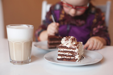 the child is eating a sweet puff cake in a cafe.