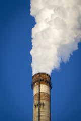 The thick smoke rises high from the industrial pipes. Pollution of the environment with waste...