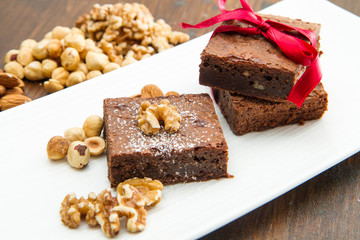 Cake chocolate brownies on white dish with nut