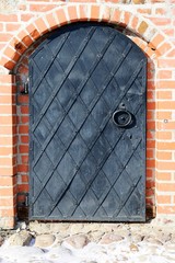 old iron door in a brick wall.