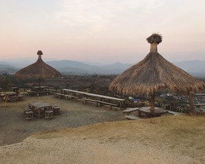 Picturesque rural view of countryside village surrounded by mountains. Sunset magnificent picture of nature in the Northern Thailand. Farm in the valley during dry season.Film effect.