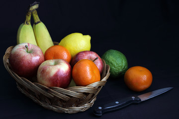 Dark Food - Chiaroscuro mixed fruit in wicker basket with dark background