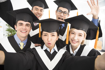 happy graduates making selfie photo in classroom.