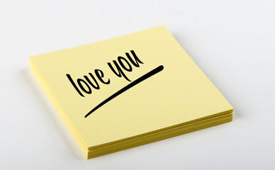 Concept of note with the words Love you written on yellow paper. Mockup.