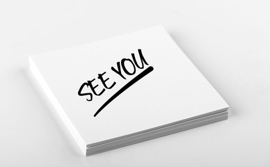 Concept of note with the words See you written on white paper. Mockup.