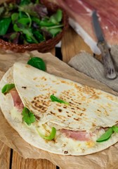 Italian flatbread piadina with prosciutto ham and mozzarella cheese