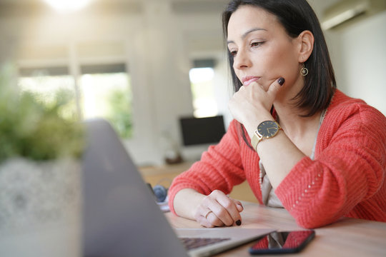 Brunette Girl Being Thoughtful In Front Of Laptop