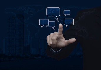 Businessman point to social chat sign and speech bubbles over world map and modern city tower, Social network concept, Elements of this image furnished by NASA