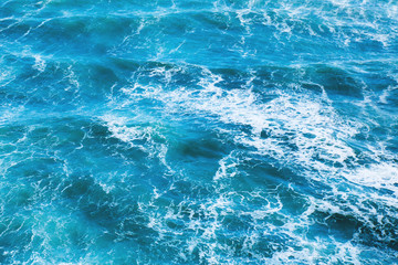 Fototapeta na wymiar Blue sea water with waves and white foam for background.