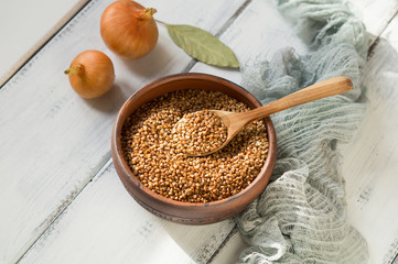 buckwheat groats in a clay bowl, onions, bay leaves