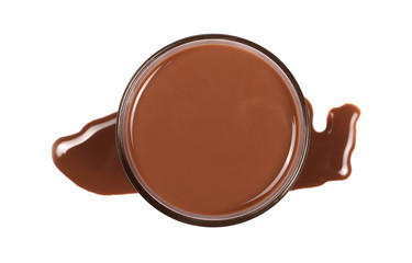 Chocolate milk in glass with spillage, puddle isolated on white background, top view