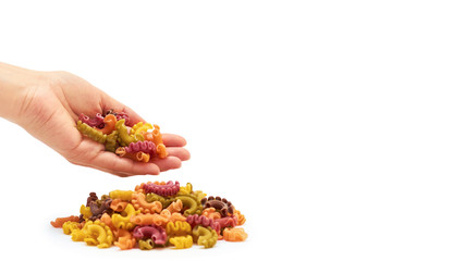 Female hand holds raw colored macaroni. Isolated on white background. copy space, template