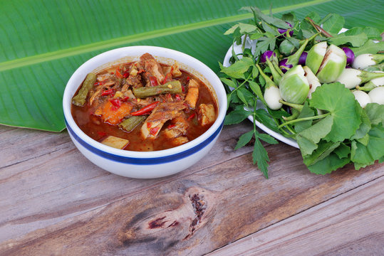 Spicy and hot Style Fish Soup with Fermented Fish's Stomach in white bowl and fresh vegetable (Thai food, and Thai language " Kang Tai Pla")
