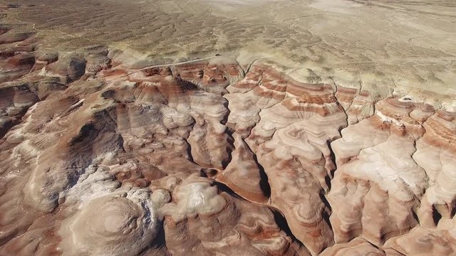 Flying in towards dirt road from high above over Mars desert near Hanksville Utah.