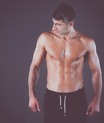 muscular man. Muscular man on a grey background showing muscles. Fitness instructor. Fitness professional. Workout. Men's fitness.