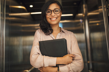 Smiling business woman in office elevator © Jacob Lund