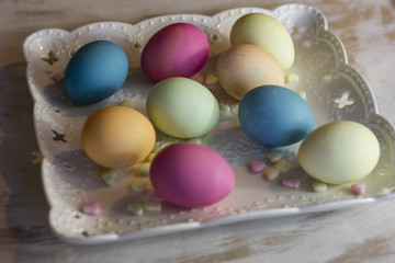 Naklejka na ściany i meble colorful easter eggs on a plate and a dark wooden background