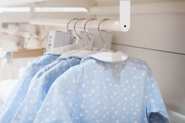 Витрина с разноцветными вещами на вешалке, крупным планом
