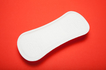 Close-up, white sanitary pad on red background.