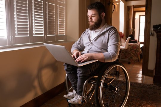 Disabled man using laptop at home