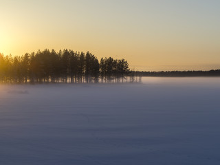 Winter landscape.Sunset on the frozen lake in the woods. 