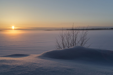 Winter landscape.Sunset on the frozen lake in the woods. 