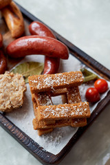 German hearty lunch in the pub. Grilled sausages, stewed cabbage, croutons, sauce. Beer snack