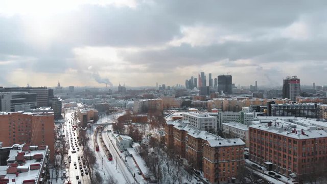 Smooth aerial shot of industrial Moscow district, cloudy cityscape scene, old soviet buildings around railways, Belarusian railway station.