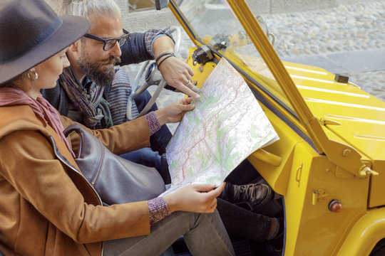 Woman and man talking looking at map. Caucasian couple in love roadtrip vacation italian travel on convertible car