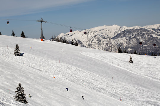 People skiing down the slope. Ski slope in winter sunny day at the mountain ski resort of Alpbachtal, Wildschonau, Austria
