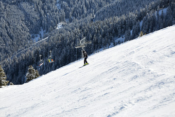 Fototapeta na wymiar People skiing down the slope. Ski slope in winter sunny day at the mountain ski resort of Alpbachtal, Wildschönau, Austria