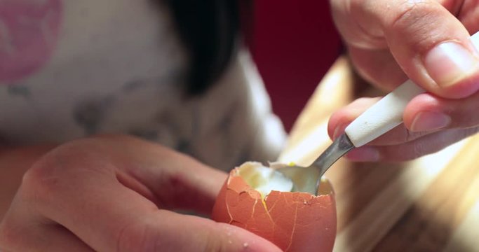 Close-up of person eating soft boiled egg - oeuf a la coque