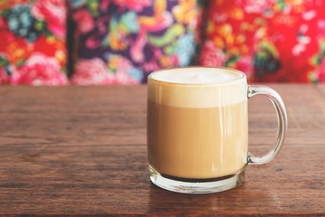 a cup of hot latte coffee on wooden table