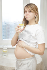 Vertical photo of pregnant woman drinking water