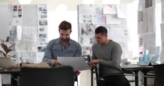 Designers looking at architectural plans in a creative workspace