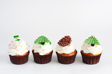 Decorated new year cupcakes standing in a row on white background