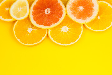 Sliced ​​citrus fruit, lemon, orange and grapefruit lie on top of each other.