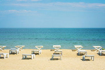 Sunny empty beach with sunbeds