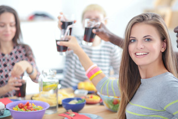 Top view of group of people having dinner together while sitting at wooden table. Food on the table. People eat fast food. Portrait of a girl