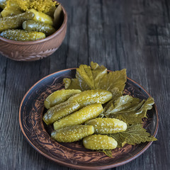 Pickled cucumbers on brown plate.