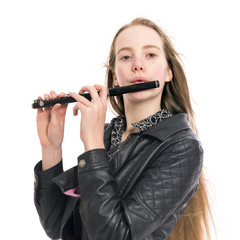 young blond teen girl plays black wooden piccolo flute in studio against white background