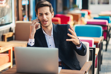Young entrepreneur working on laptop and phone