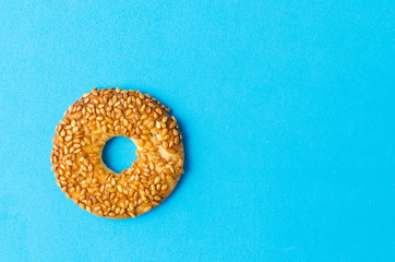 Round cookies with sesame seeds on a bright blue background.