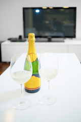 Bottle and glass of champagne in a living room