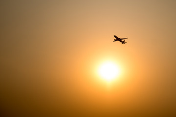 Airplane and the sun with sunset background.
