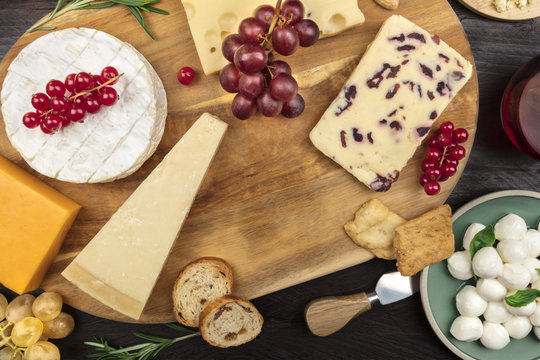 Various types of cheese on a dark rustic background with copy space